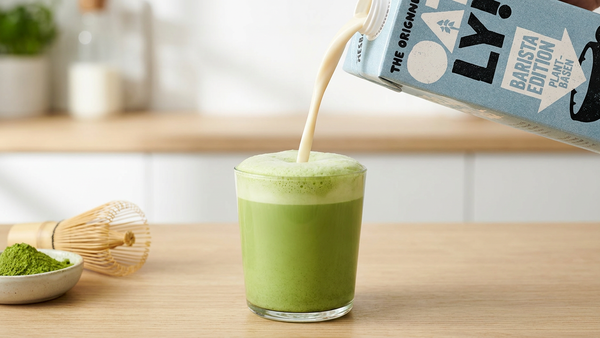 Oatly Barista Haferdrink wird in den Matcha Latte gegossen